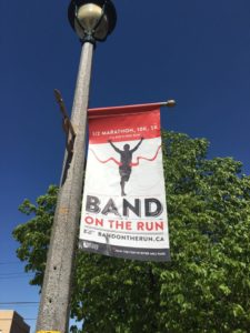 An outdoor banner on a downtown Huntsville light post that reads: Band on the Run