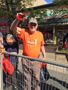 A man cheers from the sidelines of the race route.