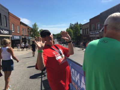 A person smiles for the camera on the sidelines of the race route.