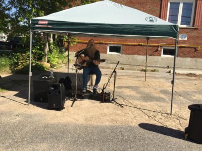 A man plays guitar along the race route.