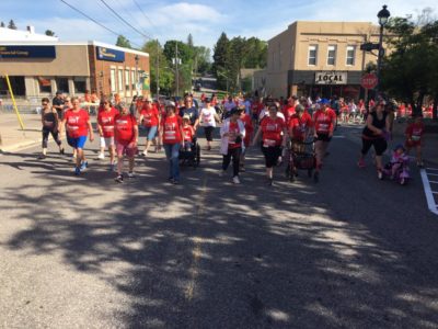 A large group of people walks along the race route.