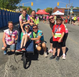 People in colourful tie-dyed shirts pose for a photo near the race route.