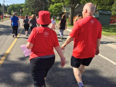 Two people walk away from the camera as they walk along the race route.