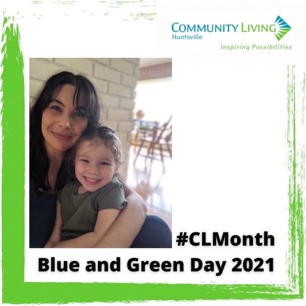 A mother and daughter wear green and pose for the camera