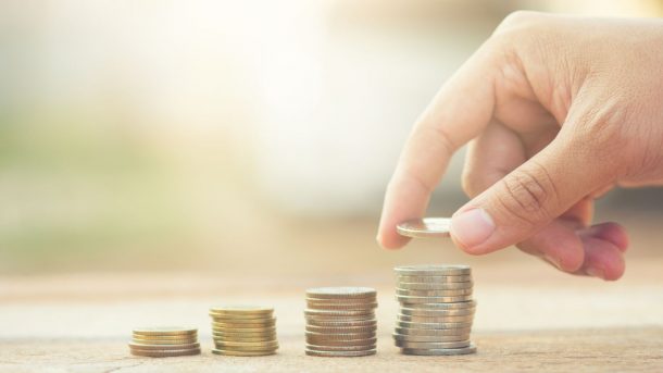 Stock photo of a hand stacking coins.