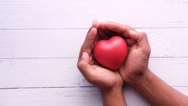 Hands holding a heart-shaped ball