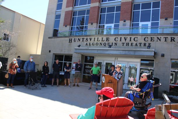 Suzanne Willett stands at a lectern to address a crowd outside Huntsville Civic Centre 