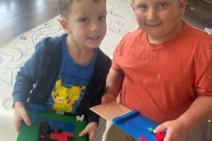 2 boys holding their Lego creations.
