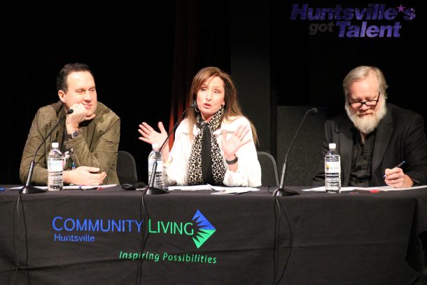 3 judges seated at a table with a black table cloth that reads: community living huntsville. the judge in the middle, a woman, talks to someone who is off camera.