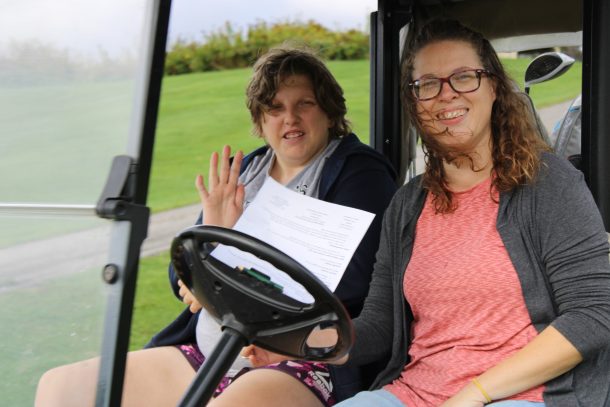 2 smiling women in a golf cart