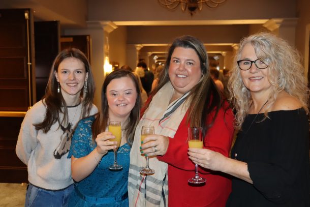 4 smiling women holding mimosas