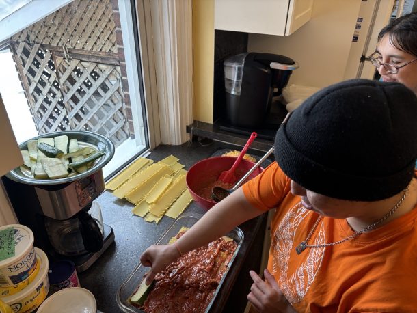 2 women in a kitchen preparing a lasagna