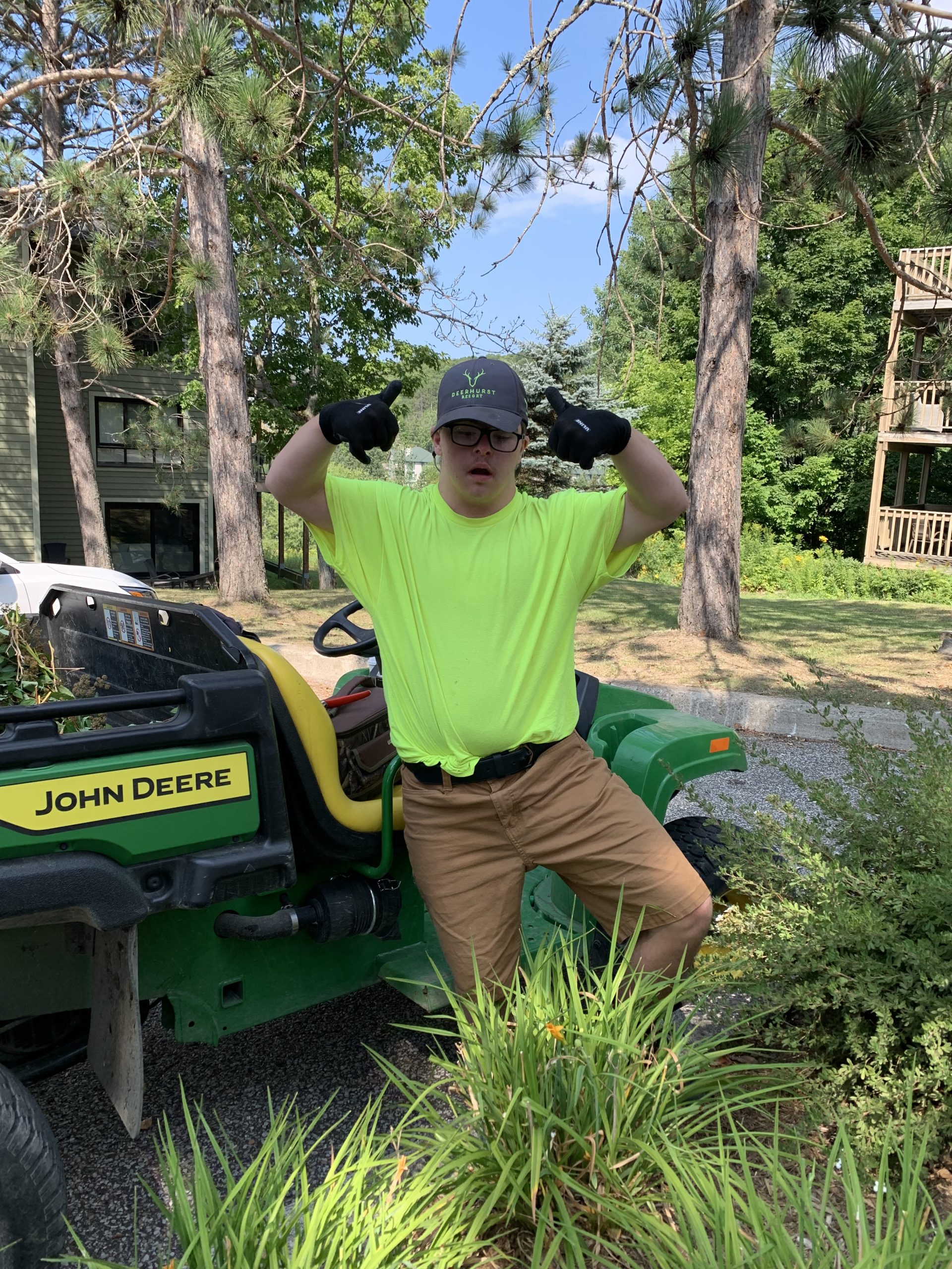 A young man in a neon green T-shirt and grey ball cap doing landscaping work.