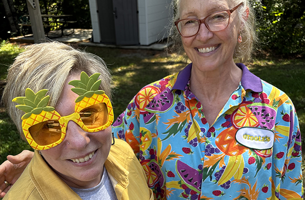 2 smiling women in colourful fruit-themed outfits