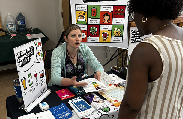 An employee approaches a Wellness Fair for Staff booth offered by the Simcoe Muskoka District Health Unit.