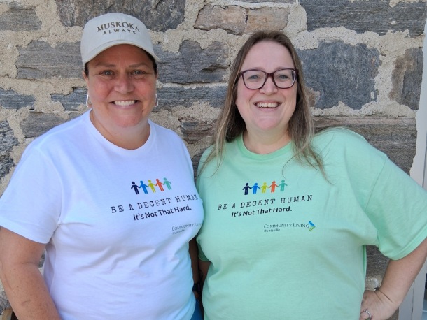 2 women in Community Living T-shirts that read, "Be a decent human being, it's not that hard."